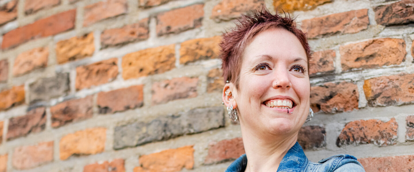 Jongedame staand tegen een oude muur