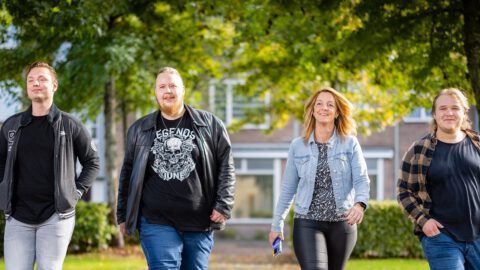 Vier mensen wandelen naast elkaar in de wijk