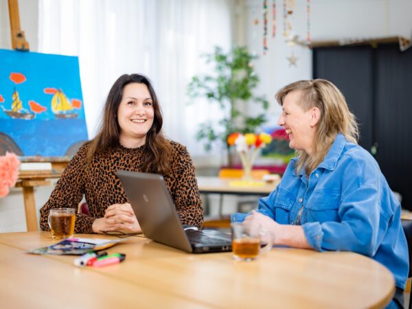 Twee vrouwen in gesprek aan een tafel